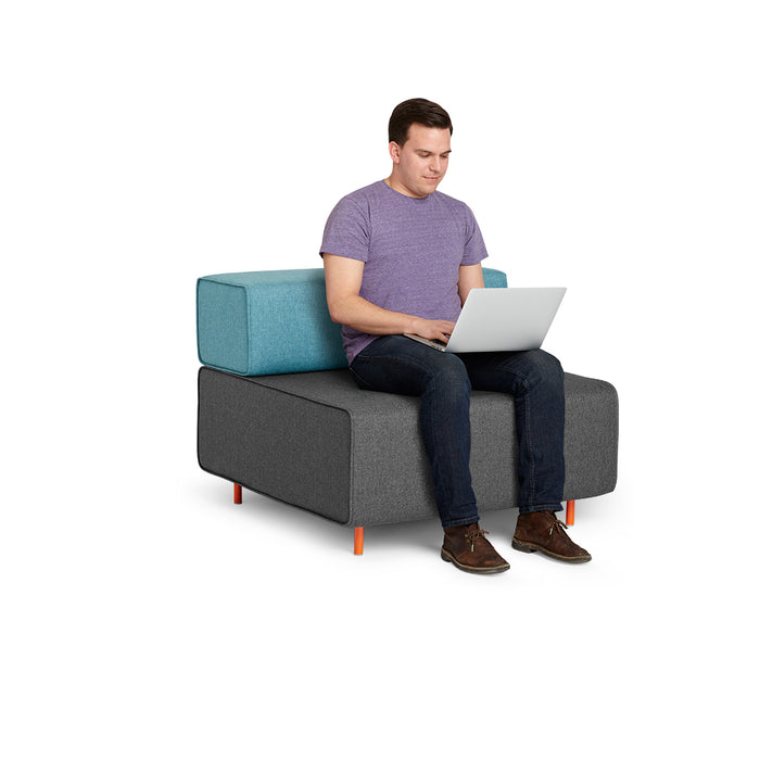 Man sitting on a modular sofa working on a laptop against white background. (Dark Gray-Blue)