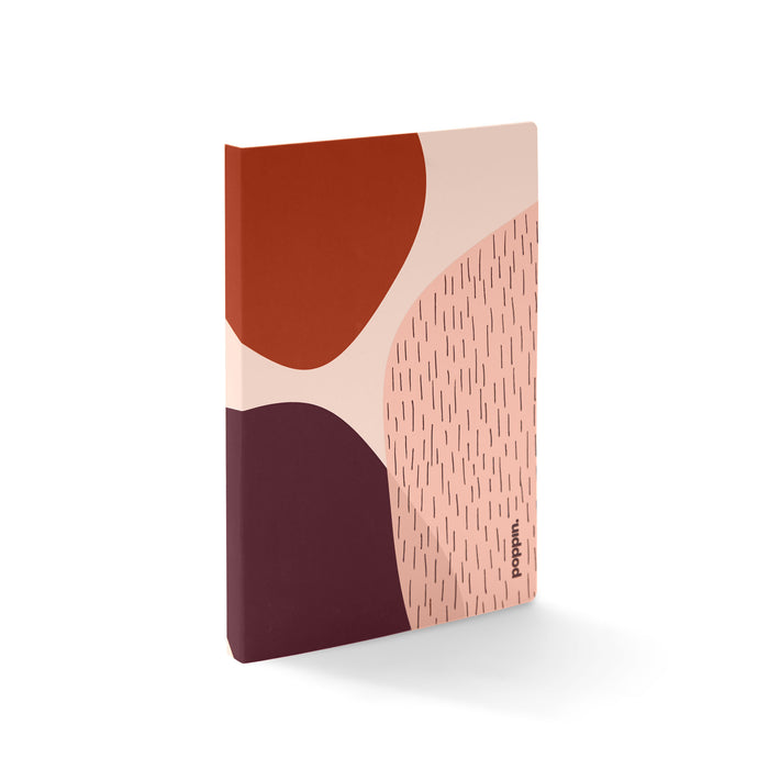 Abstract design notebook with pastel colors and geometric patterns standing against white background. (Blush)