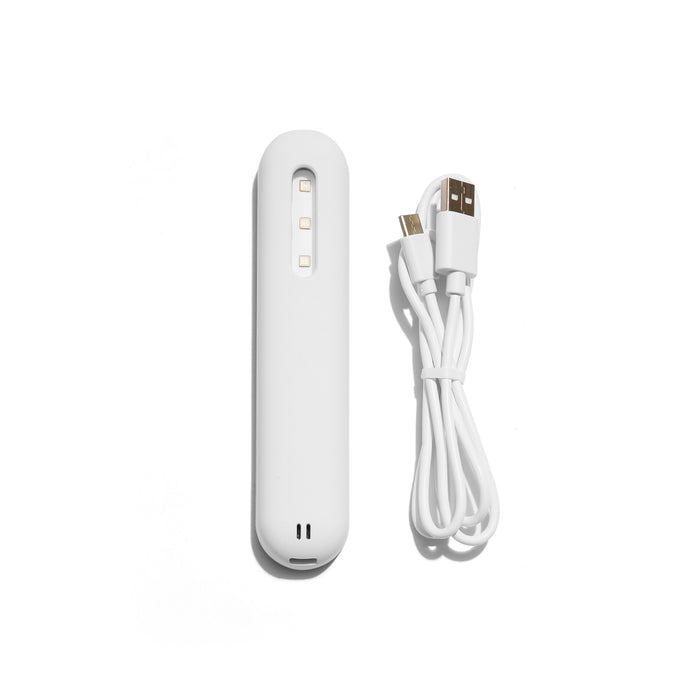 White portable USB battery pack with charging cable on white background. 