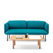 Modern teal sofa with wooden coffee table and books on white background 