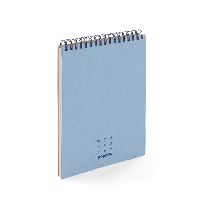 Blue spiral notebook with white lettering on light background. (Coast)