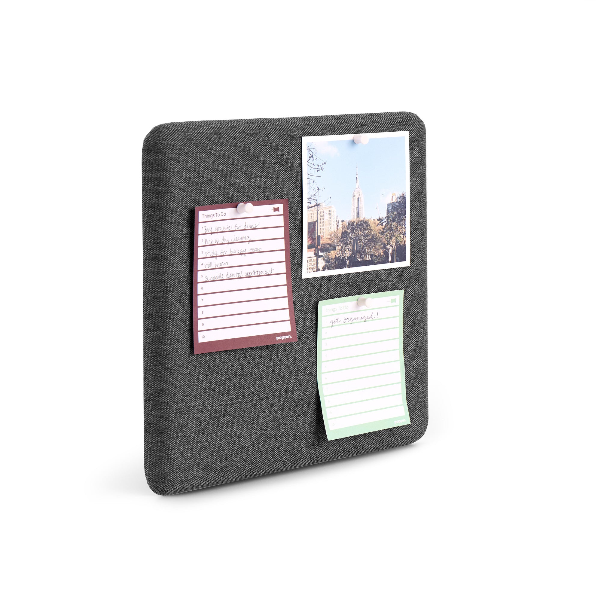 Gray fabric pinboard with notes and a postcard on white background. 