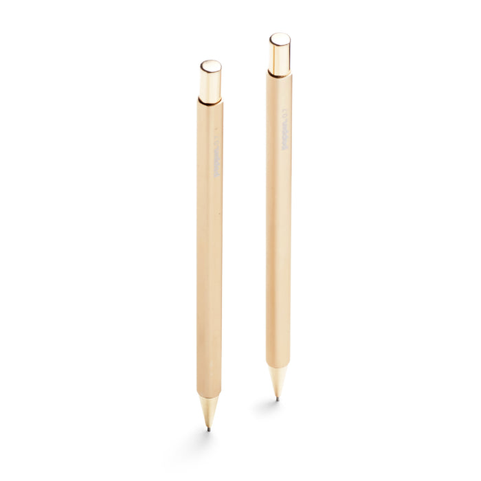 Two sleek gold designer pens isolated on white background. 