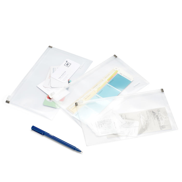 Clear plastic document folders with papers and a blue pen on white background. 