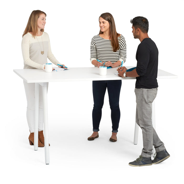 Three people standing and talking around a white table in a bright room. (White-72&quot; x 36&quot;)(White-72&quot; x 36&quot;)